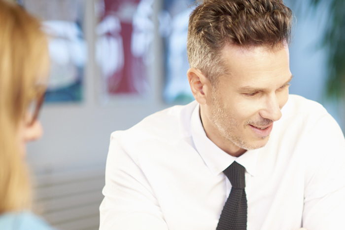 Man in shirt and tie looking downwards