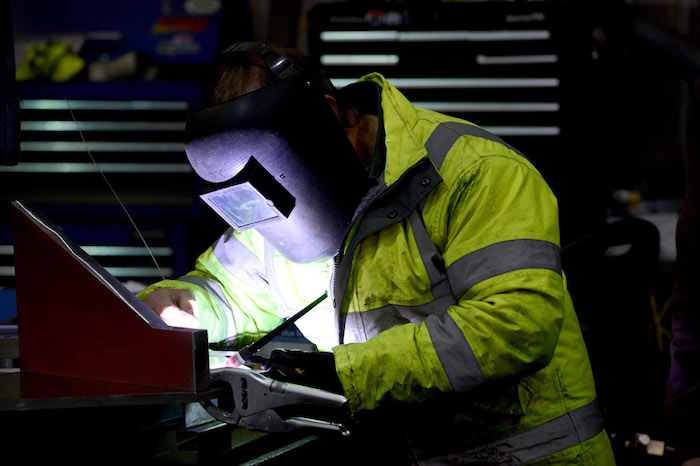 Person wearing PPE working in a steel fabrication engineering environment