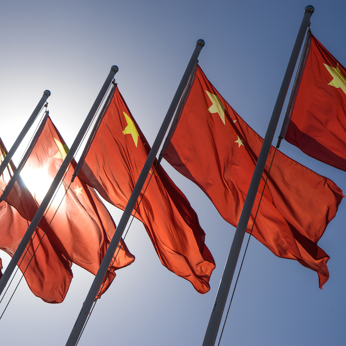 Row of Chinese flags against a blue sky