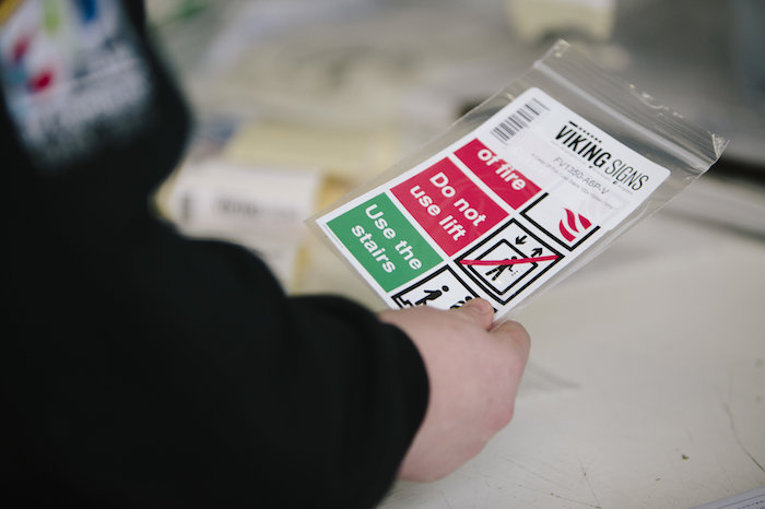 Man holding a safety sign manufactured by Viking Signs