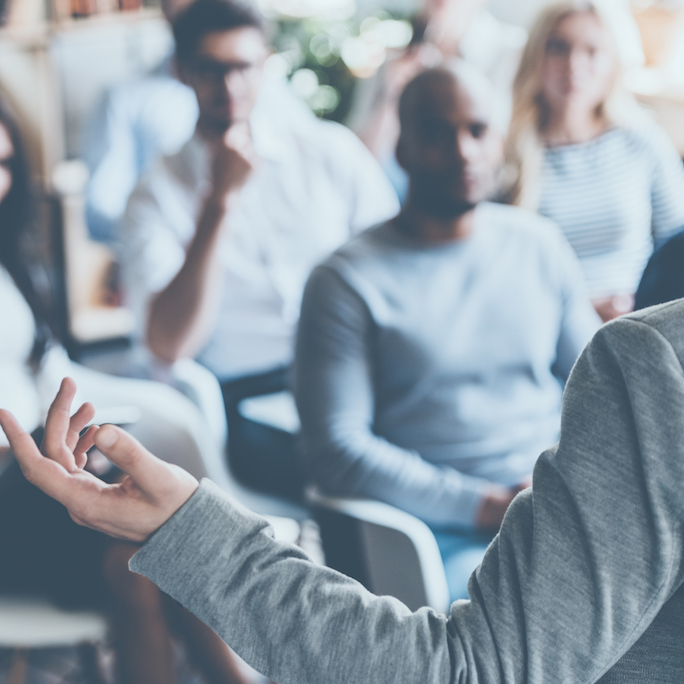 Small group of people sat down at an event listening to a presentation