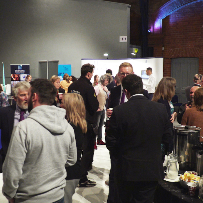 Large group of people stood up mingling at a Business Conference