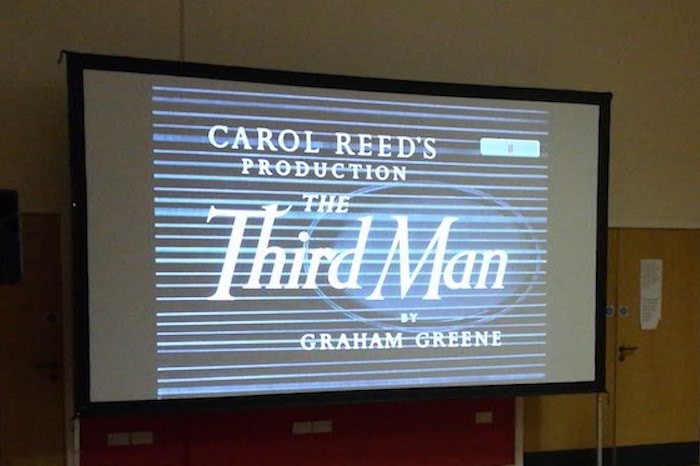 Large projector screen displaying the words Carol Reed's production The Third Man by Graham Greene