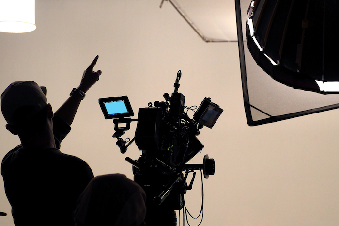 Image of man operating a video camera with professional lighting rig