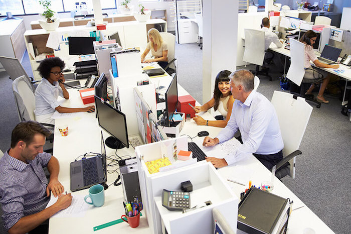Busy office workspace with people sat at desks