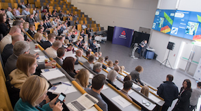 Large group of people sat down at an event listening to a presentation