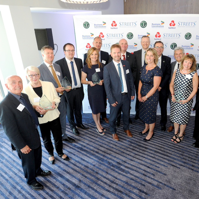 Group of people smartly dressed smiling for photo at an event