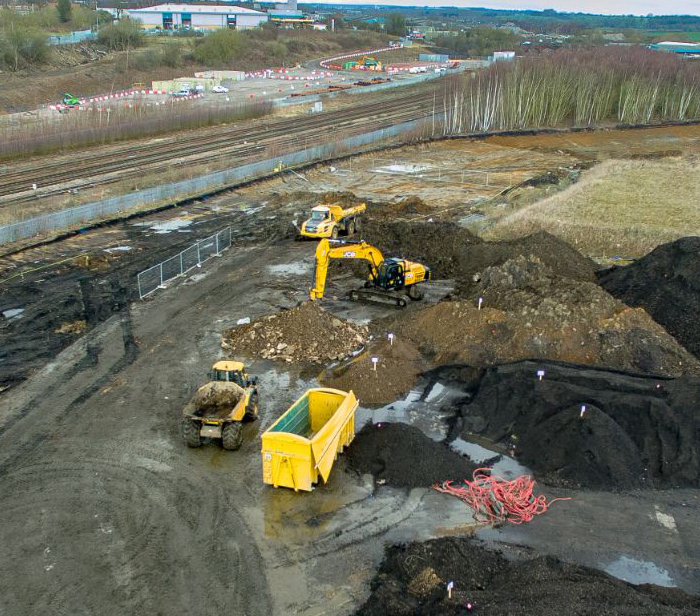 Aerial view of excavation site with large yellow heavy plant machinery