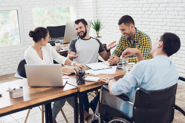 4 people sat around a desk working