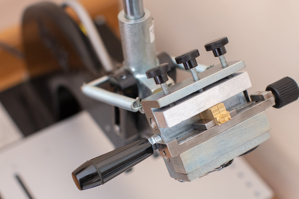 Close up of a hot foil machine used in the process of metallic de-bossing of leather items