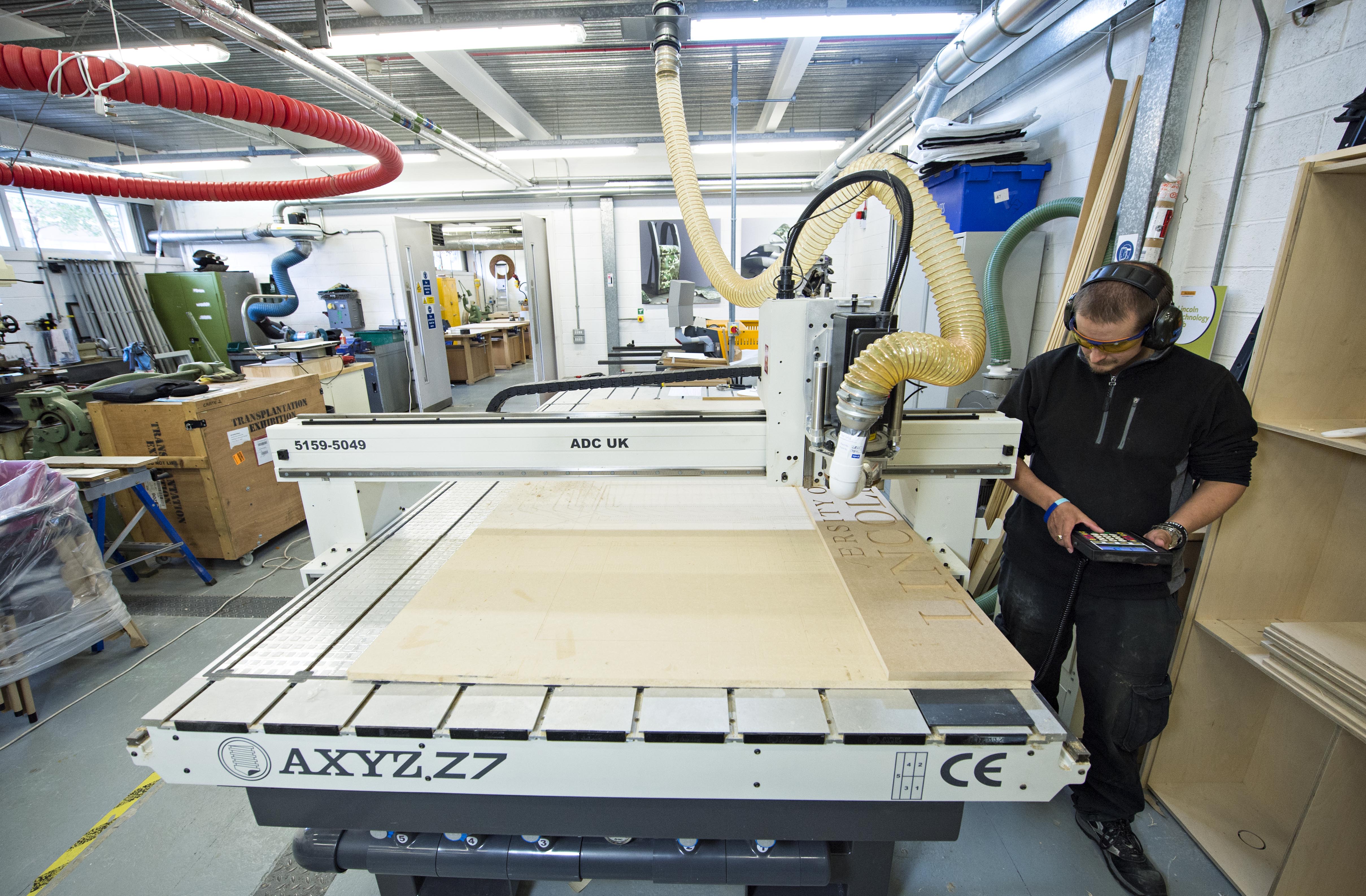 Image of worker using manufacturing equipment