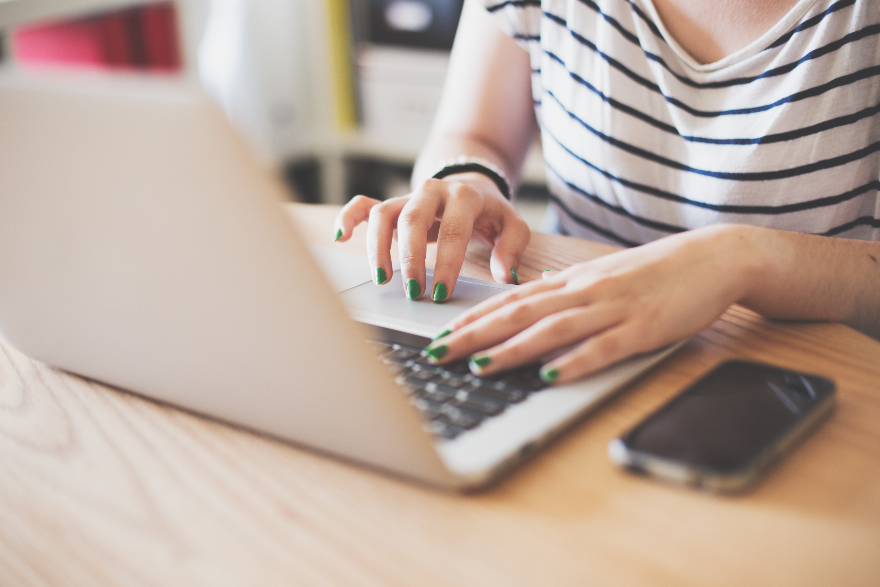 Lady on laptop with mobile phone beside her