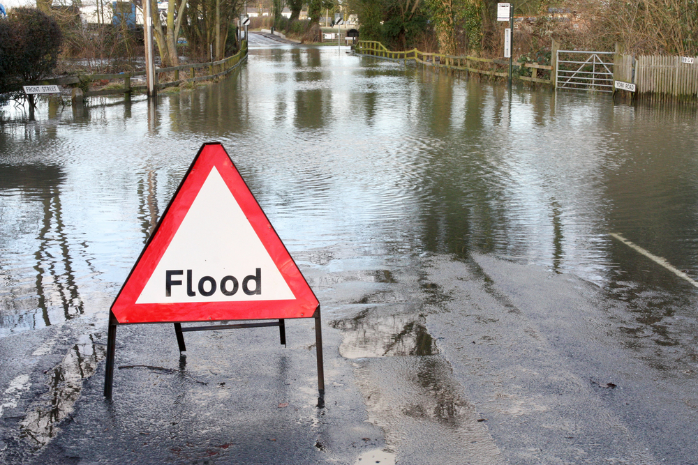 Flood sign in front of flooded area