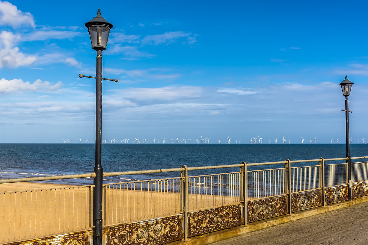 Image of the sea with wind farm in the distance