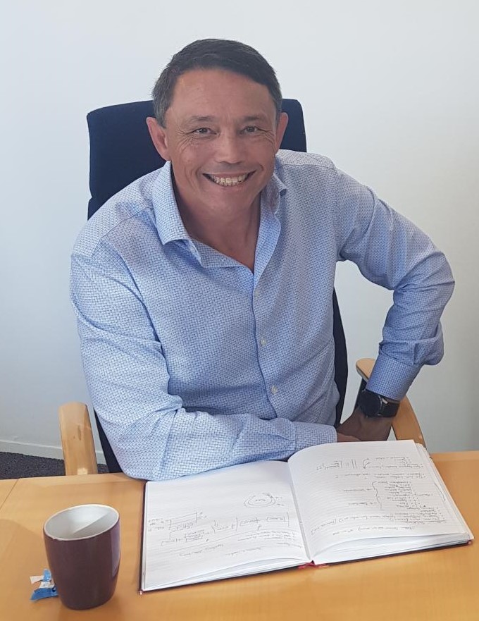 Image of man sat at desk with notepad