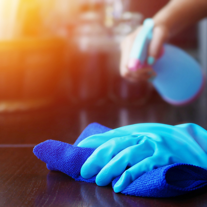 Person cleaning and wiping surface with cloth