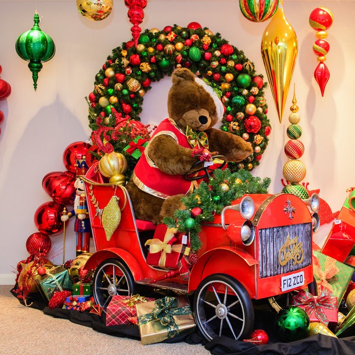 Festive teddy bear surrounded by Christmas decorations