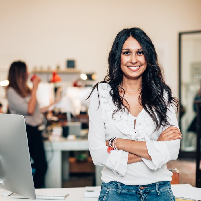 Lady stood in front of desk smiling