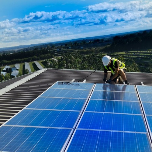 Engineer fixing solar panel on roof of farm