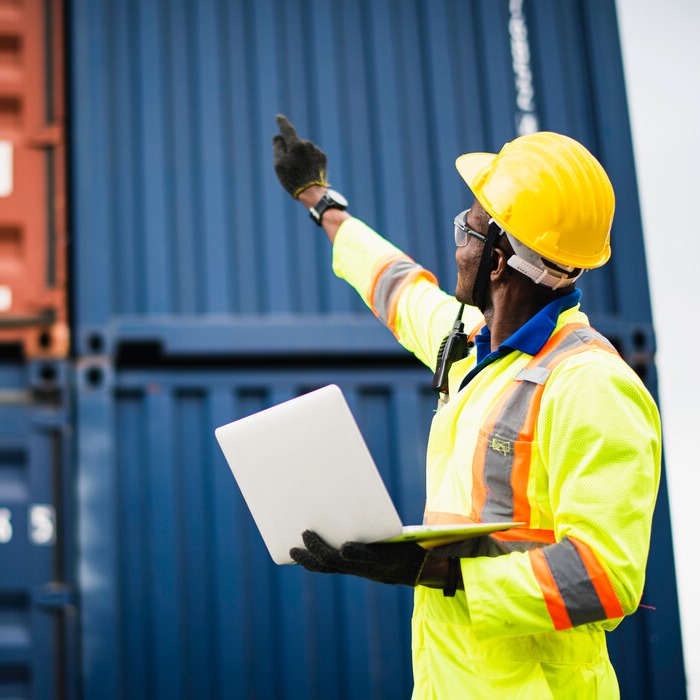 Gentleman in high-vis work clothes pointing at containers