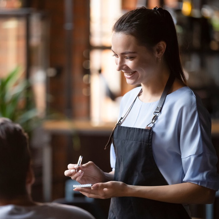 Lady taking order on notepad at cafe