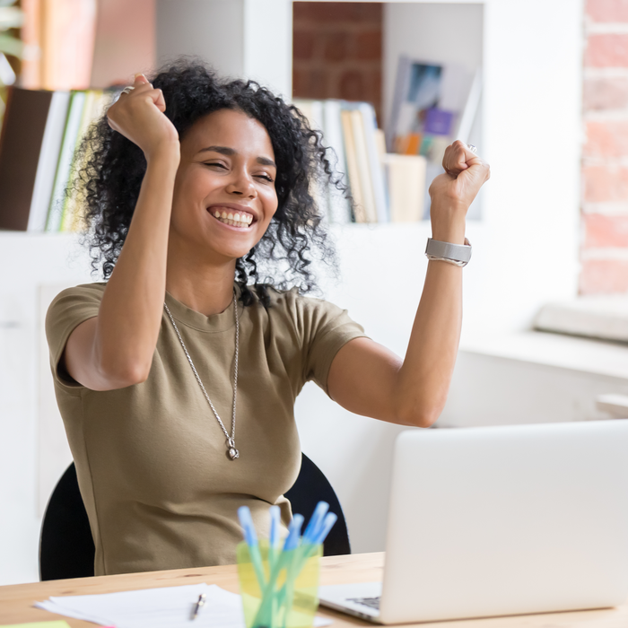 Woman sat at desk excited