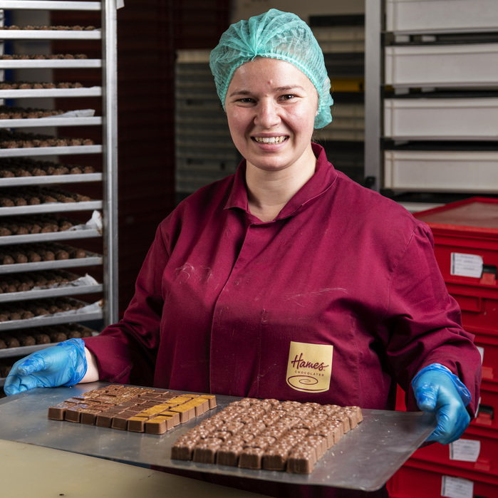 Worker at Hames Chocolates holding a tray of chocolates