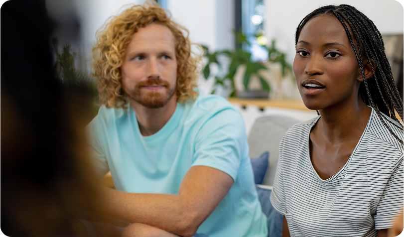 A man and woman having a meeting with another person, back of head in part of the picture
