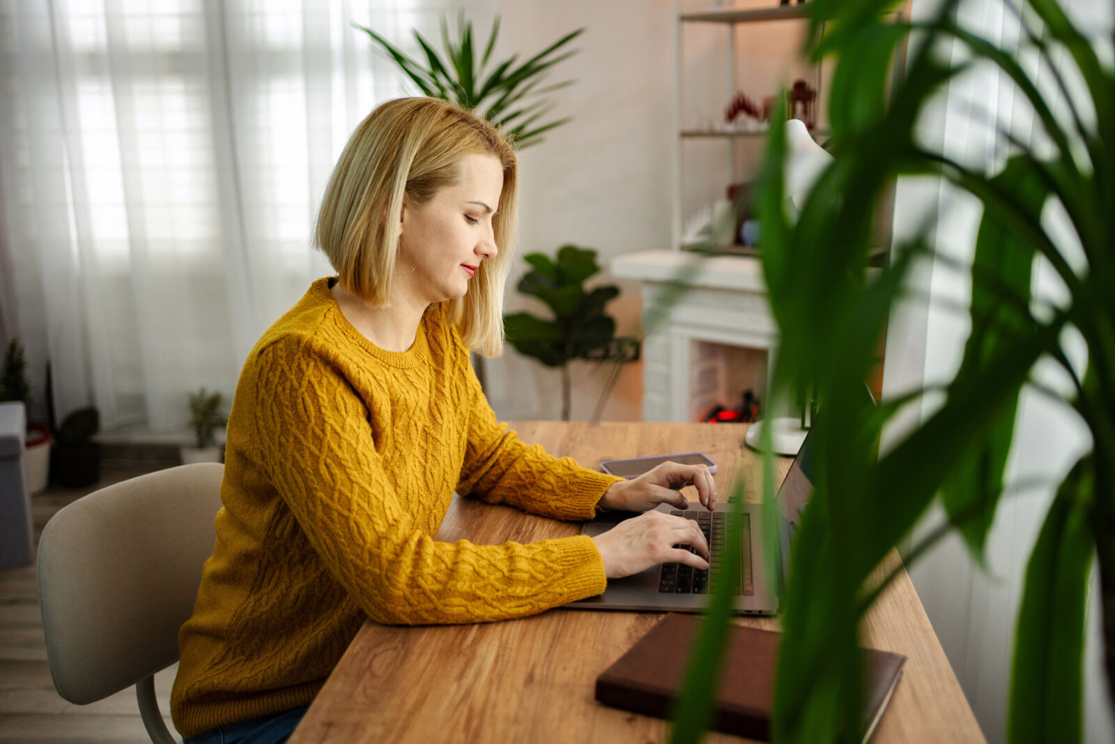 Focused woman working on laptop in home office